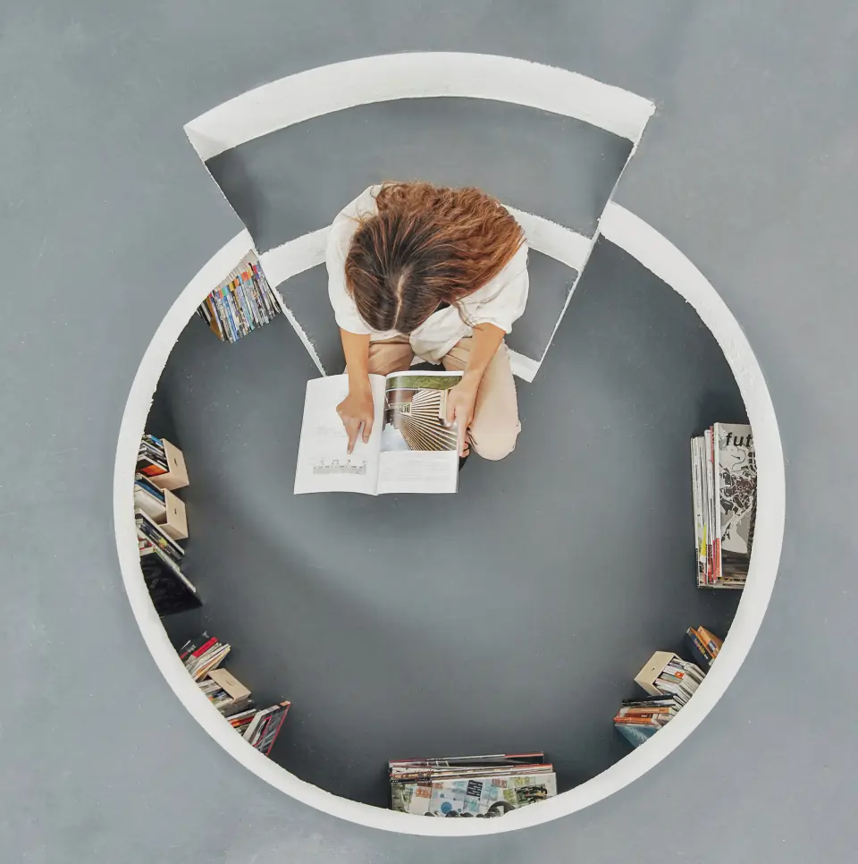 Overhead view of a round reading nook lined with books