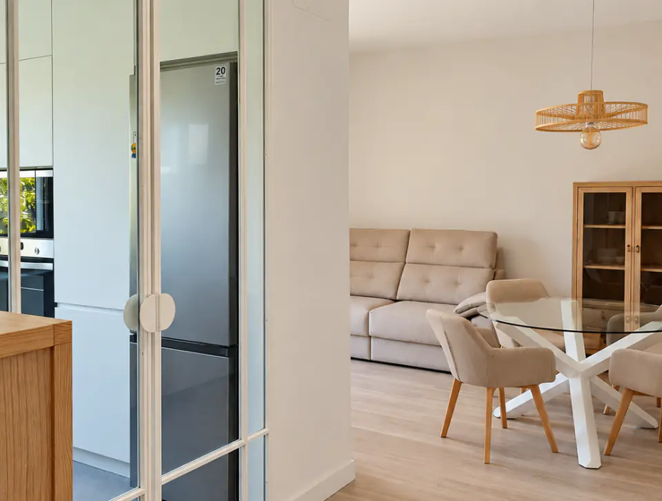 Hallway with a tall fridge unit and the dining area beyond