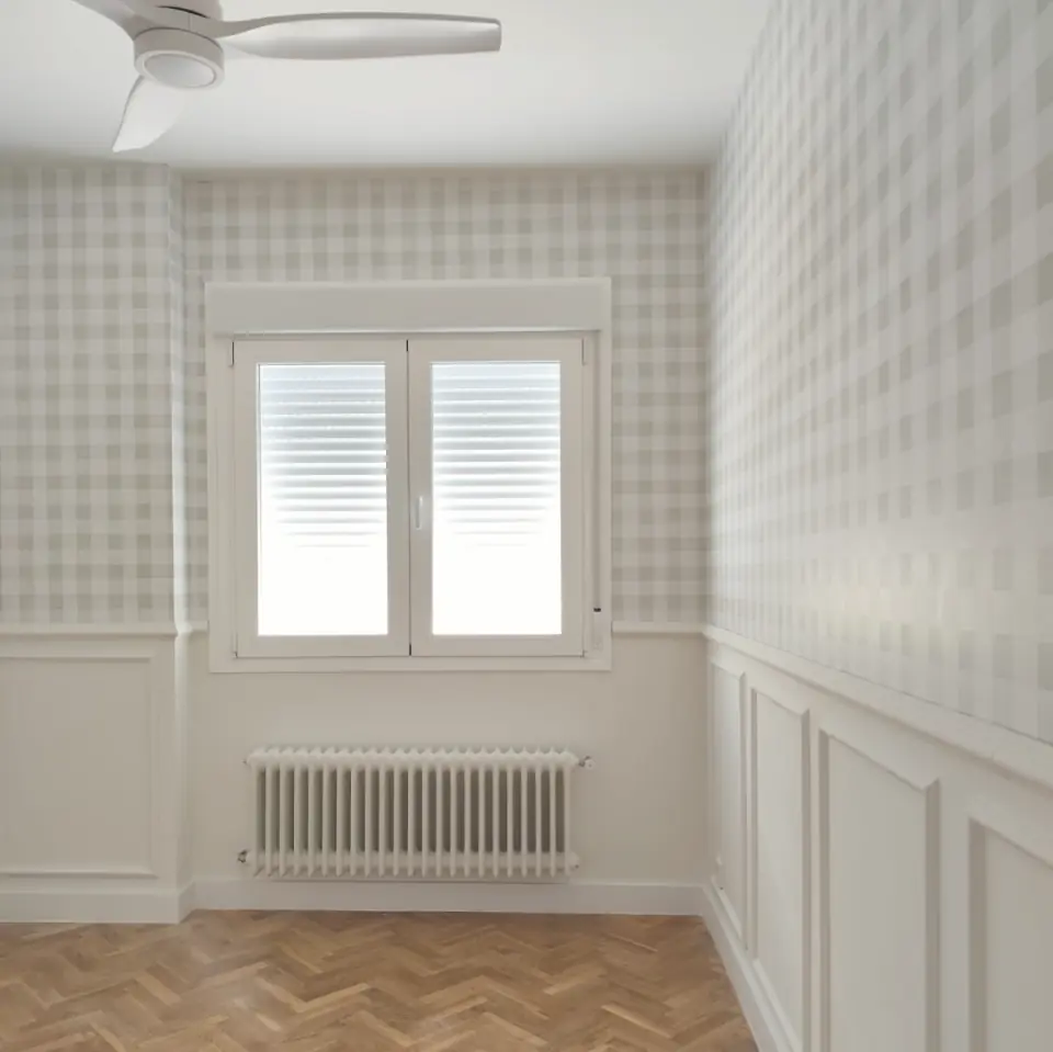 Bedroom with panelled walls and patterned wallpaper