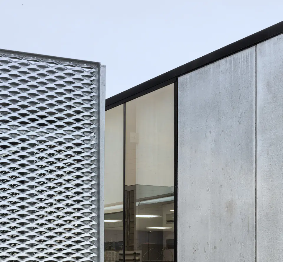 Expanded metal mesh panel beside a concrete façade