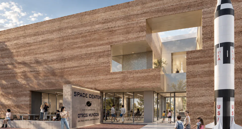 Rammed-earth façade of the space centre with a rocket beside the entrance